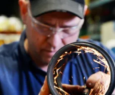 MIR machinist finishing a machined ring, sparks flying